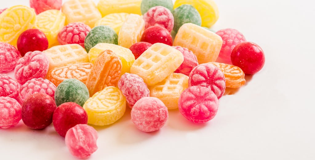 A vibrant display of assorted colorful hard candies on a white background.